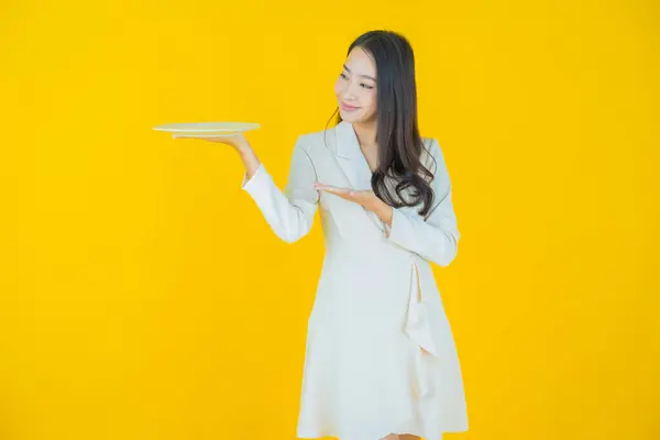 肖像画美しい若いアジアの女性の笑顔とともに空のプレート料理上の色の背景 — ストック写真