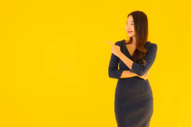 İzole edilmiş sarı arka planda hareketli güzel Asyalı kadın portresi.