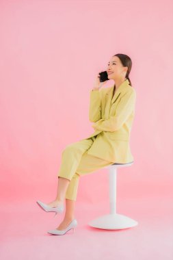 Güzel Asyalı iş kadını portresi. Arka planda kahve fincanı ve akıllı cep telefonu kullanıyor.