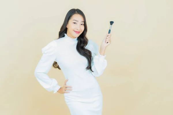 Portret Piękna Młoda Azjatycka Kobieta Makijażu Pędzel Kosmetyk Tle Koloru — Zdjęcie stockowe