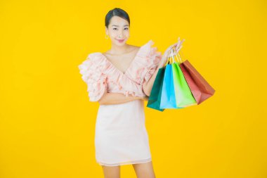 Portre güzel Asyalı kadın tebessümü ile renk arka planında alışveriş torbası