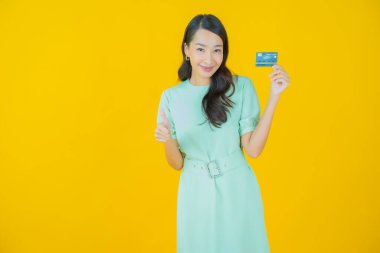 Güzel bir Asyalı kadının portresi. Renkli kredi kartıyla gülüyor.