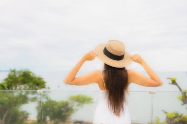 Portriat güzel genç Asyalı kadın deniz manzaralı balkonda mutlu bir gülümseme