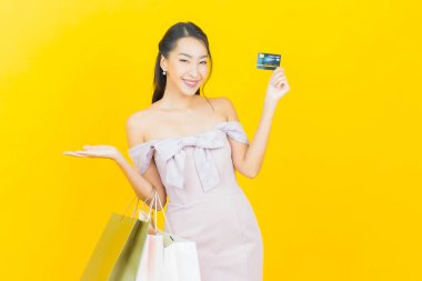 Portre güzel Asyalı kadın tebessümü ile renk arka planında alışveriş torbası