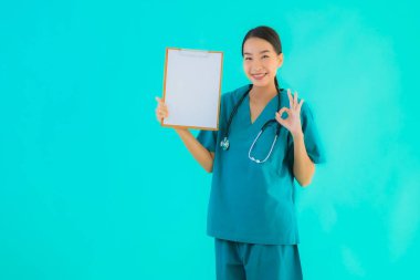 Fotokopi için boş kâğıt tahtası olan güzel Asyalı genç doktor kadın hastane ve klinikteki sağlık hizmetleri konseptinde mavi izole edilmiş arka plan.