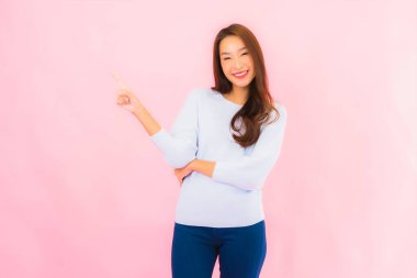 Portrait beautiful young asian woman smile with action on pink isolated background