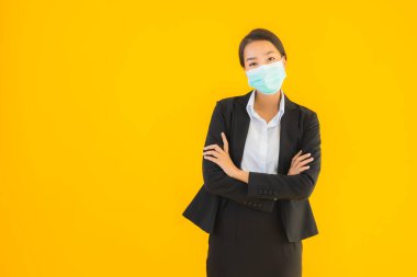 Güzel genç iş kadını portresi Korunmak için maske takıyor 19 koronavirüs sarı izole arka planda