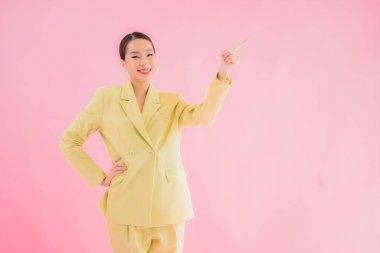 Portre güzel Asyalı genç iş kadını pembe arka planda gülümsüyor