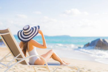 Güzel bir Asyalı kadının portresi. Rahatlayın. Plaj okyanusunda tatil yaparken gülümseyin.