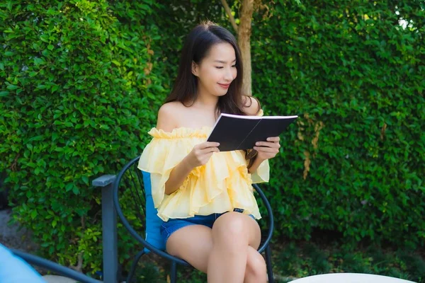 Young asian woman read book around outdoor garden nature view