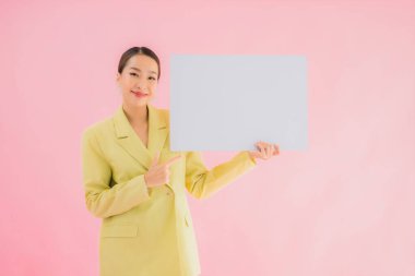 Güzel Asyalı genç iş kadını portresi. Arka planda beyaz ilan panosuyla gülümsüyor.