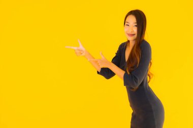 İzole edilmiş sarı arka planda hareketli güzel Asyalı kadın portresi.