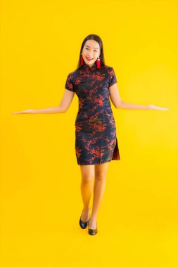 Güzel bir portre genç Asyalı kadın Çin 'in yeni yıl konsepti için sarı izole edilmiş arka planda Çin elbisesi giyiyor.