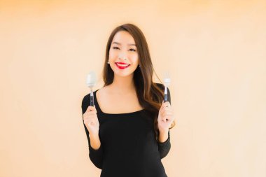 Kaşığı ve çatalı olan güzel Asyalı bir kadının portresi izole edilmiş renkli arka planda yemeye hazır.