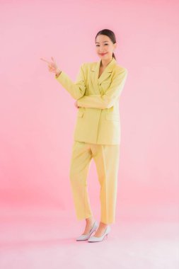 Portre güzel Asyalı genç iş kadını pembe arka planda gülümsüyor