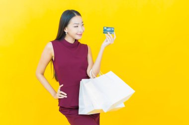 Portre güzel Asyalı kadın tebessümü ile renk arka planında alışveriş torbası