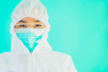 Güzel, genç Asyalı doktor kadın portre. Koronavirüsten ya da mavi arka planda kovid19 'dan korunmak için ppe ya da kişisel koruyucu ekipman takıyor.