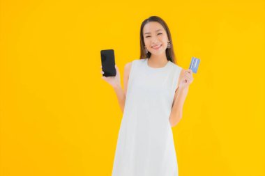 Çevrimiçi alışveriş için kredi kartı olan güzel bir Asyalı kadın portresi.