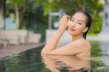 Güzel bir Asyalı kadın portresi. Rahatlayın. Yüzme havuzu etrafında gülümseyin.