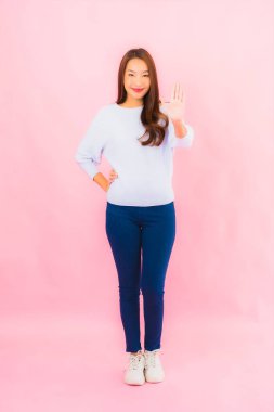 Portrait beautiful young asian woman smile with action on pink isolated background