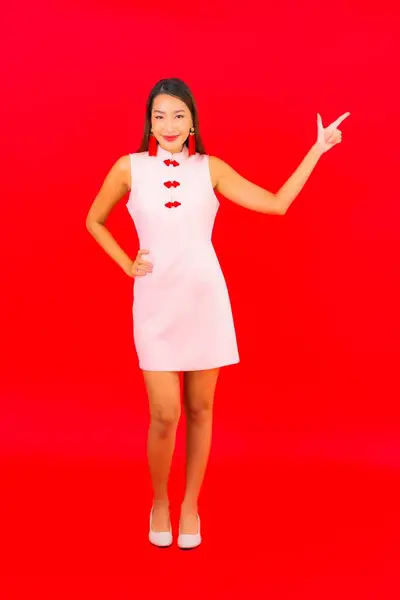 亚洲年轻貌美的女子穿着红色背景的中国新年服装 — 图库照片