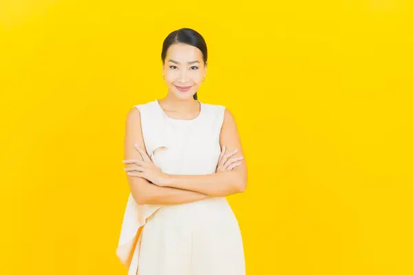 亚洲年轻貌美的女子面带微笑 黄褐色背景的动作 — 图库照片