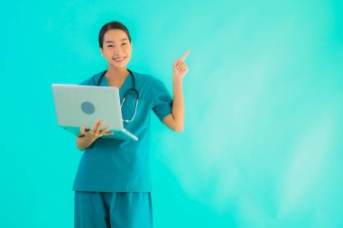 Mavi izole arka planda dizüstü bilgisayarı olan güzel Asyalı doktor kadın portresi.