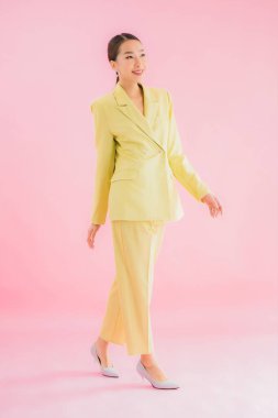 Portre güzel Asyalı genç iş kadını pembe arka planda gülümsüyor