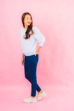 Portrait beautiful young asian woman smile with action on pink isolated background
