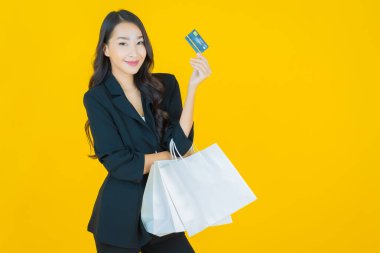 Renkli arka planda akıllı cep telefonuyla güzel Asyalı kadın gülümsemesi