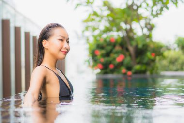 Güzel bir Asyalı kadının portresi. Gülümse. Yüzme havuzunda rahatla.