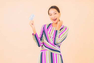 Akıllı cep telefonu ve kredi kartı olan güzel bir Asyalı kadın portresi.