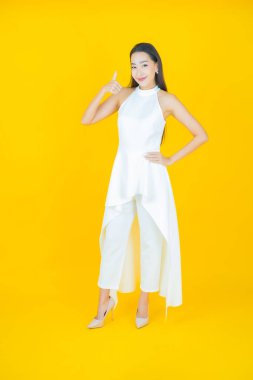 Portre güzel Asyalı kadın gülümsüyor. Renkli arka planda hareket var.