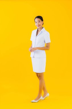 Güzel, Asyalı genç bir kadının portresi. Hemşire gülümsemesi. Klinikteki ya da sarı izole edilmiş arka plandaki hastalar için çalışmaya hazır.