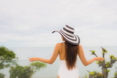 Portriat güzel genç Asyalı kadın deniz manzaralı balkonda mutlu bir gülümseme