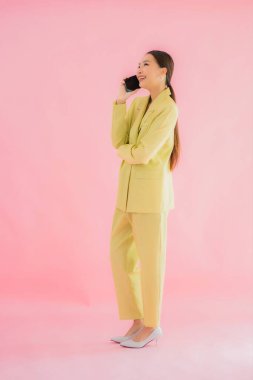 Güzel Asyalı iş kadını portresi. Arka planda kahve fincanı ve akıllı cep telefonu kullanıyor.