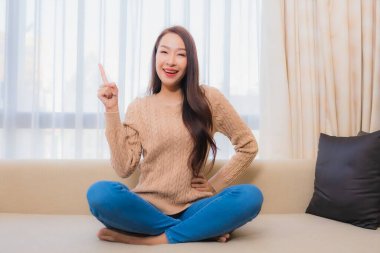 Güzel bir Asyalı kadın portresi rahatla. Gülümse. Yatak odasının iç dekorasyonunda mutlu ol.