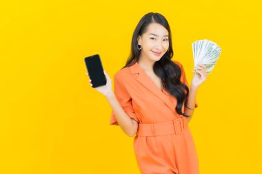 Asyalı güzel bir kadının portresi. Bir sürü para ve parayla gülümsüyor.