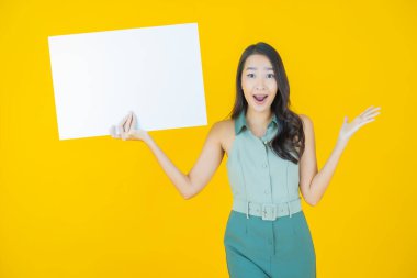 Renkli arka planda boş beyaz ilan panosu olan güzel Asyalı kadın portresi