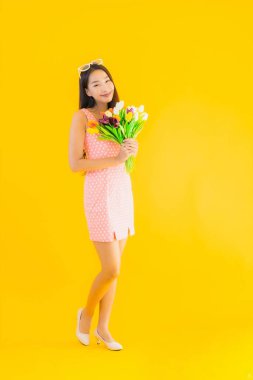 Sarı izole edilmiş arka planda renkli çiçekli güzel Asyalı kadın portresi.