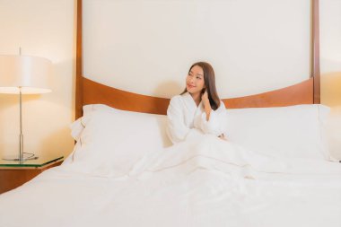 Güzel bir Asyalı kadının portresi. Gülümse. Yatak odasında rahatla.