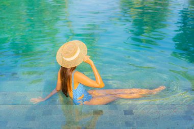 Güzel bir Asyalı kadın portresi. Rahatlayın. Yüzme havuzunun, deniz kenarındaki okyanus manzarasının keyfini çıkarın.