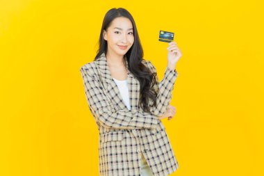 Güzel bir Asyalı kadının portresi. Renkli kredi kartıyla gülüyor.