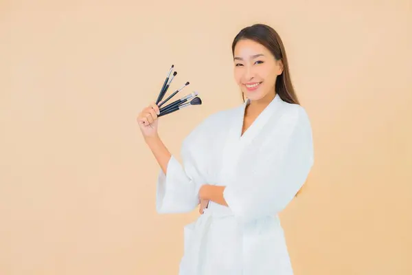 Renkli Arka Planda Makyaj Fırçası Olan Güzel Bir Asyalı Kadın — Stok fotoğraf