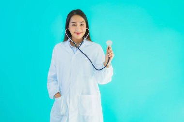 Klinikte ya da mavi izole edilmiş arka planda hastanede kullanmak üzere steteskoplu güzel Asyalı genç doktor kadın portresi.