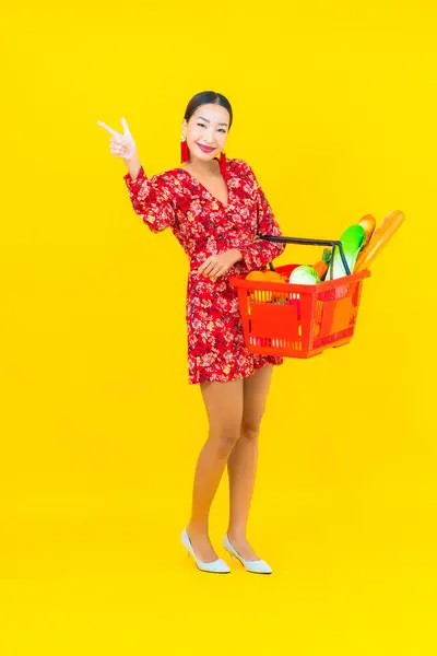 スーパーマーケットからバスケットやカートで食料品と肖像画の美しい若いアジアの女性 — ストック写真