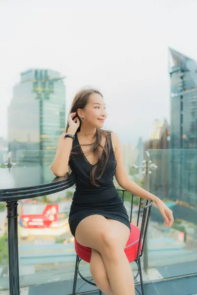 Portrait beautiful young asian woman relax enjoy restaurant on the rooftop around city view