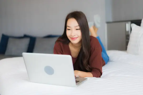 Güzel Bir Asyalı Kadın Yatak Odasının Kısmında Bilgisayar Kullanıyor — Stok fotoğraf