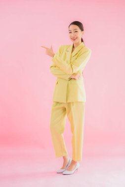 Portre güzel Asyalı genç iş kadını pembe arka planda gülümsüyor