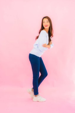 Portrait beautiful young asian woman smile with action on pink isolated background